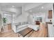 Bright living room with comfortable couch, modern coffee table, staircase, and a view into the open concept kitchen at 210 S Old Hammer Ct, Aurora, CO 80018