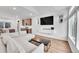 Open concept living room featuring a comfortable couch, a wall-mounted TV, and a modern kitchen in the background at 210 S Old Hammer Ct, Aurora, CO 80018