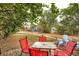 Backyard setup with two decks, blue Adirondack chairs, and red table with chairs at 3074 S Elati St, Englewood, CO 80110