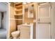 Cozy bathroom with a toilet, sink and shower with tiled wall, and open storage at 3074 S Elati St, Englewood, CO 80110