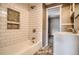 Bright bathroom featuring a subway tile shower and built-in storage shelves at 3074 S Elati St, Englewood, CO 80110
