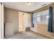 Bedroom with view into bathroom, neutral walls, carpeted floor, and blue curtains at 3074 S Elati St, Englewood, CO 80110