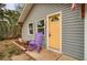 Cozy home featuring a yellow front door with a cute purple rocking chair at 3074 S Elati St, Englewood, CO 80110
