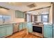 Charming kitchen with stainless steel appliances, hardwood floors, and sage green cabinets at 3074 S Elati St, Englewood, CO 80110