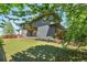 Beautiful backyard features a well manicured lawn, lush plants, and a charming gray house at 9154 E 37Th Ave, Denver, CO 80238