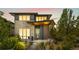 Modern home at twilight featuring attractive architectural details and warm interior lighting at 9154 E 37Th Ave, Denver, CO 80238
