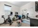 Bright home gym with exercise bike, weights, blue exercise ball, and mirrors reflecting the equipment at 9154 E 37Th Ave, Denver, CO 80238