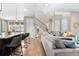 Open-concept living room with modern design, hardwood floors, a large sectional, and adjacent kitchen at 9154 E 37Th Ave, Denver, CO 80238