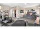 Bright main bedroom with tufted headboard, ensuite bathroom access, and sitting area with leather chaise lounge at 9154 E 37Th Ave, Denver, CO 80238