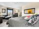 Airy main bedroom with sitting area, large window, and framed art and mirror at 9154 E 37Th Ave, Denver, CO 80238