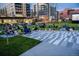 People watching a movie screen in an outdoor seating area at dusk with high rise apartment buildings nearby at 838 N Cherry St # 1, Denver, CO 80220