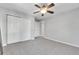 Bedroom with neutral carpet, ceiling fan, and doorway to the ensuite bathroom at 7511 S Sicily Way, Aurora, CO 80016