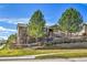 Beautiful townhome with green siding, brick accents, and a well-manicured lawn at 7511 S Sicily Way, Aurora, CO 80016