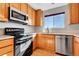 Well-lit kitchen features wood cabinets, stainless steel appliances, and a window over the sink at 7511 S Sicily Way, Aurora, CO 80016