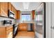 Bright kitchen features wooden cabinetry and stainless steel appliances at 7511 S Sicily Way, Aurora, CO 80016