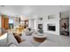 Bright living room featuring a fireplace and seamless transition to the kitchen and outdoor balcony at 7511 S Sicily Way, Aurora, CO 80016