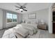 This main bedroom features a ceiling fan, a large window, neutral decor, and light-colored furniture at 7511 S Sicily Way, Aurora, CO 80016