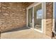 Covered patio with brick accent wall and sliding glass door entrance provides a welcoming space at 7511 S Sicily Way, Aurora, CO 80016