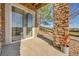 Covered patio with brick pillars and sliding glass door offers a seamless indoor-outdoor flow at 7511 S Sicily Way, Aurora, CO 80016