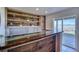 Stylish bar area with wooden shelves, a shiny countertop, and a view to the outside at 4142 S Deframe Ct, Morrison, CO 80465