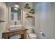 Charming powder room with modern fixtures, shiplap walls, wood shelves, and a stylish vanity at 4142 S Deframe Ct, Morrison, CO 80465