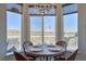 Bright breakfast nook with a chandelier and scenic views from large windows and access to a patio at 4142 S Deframe Ct, Morrison, CO 80465