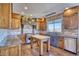 A well-appointed kitchen with custom wood cabinetry, brick backsplash, and updated stainless steel appliances with views at 4142 S Deframe Ct, Morrison, CO 80465