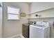 Well-lit laundry room with modern washer, dryer, shelving, and a decorative sign at 4142 S Deframe Ct, Morrison, CO 80465