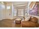 An inviting living room features hardwood floors, a leather sofa, and bright windows, perfect for relaxation at 4142 S Deframe Ct, Morrison, CO 80465