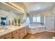 Spacious main bathroom offering a double vanity, large tub, and separate shower at 4142 S Deframe Ct, Morrison, CO 80465