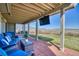 Covered patio with comfortable seating and a beautiful view of the mountains in the distance at 4142 S Deframe Ct, Morrison, CO 80465