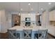 Open-concept kitchen with white cabinets, stainless appliances, and island with bar seating at 1868 Makley Loop, Castle Rock, CO 80104