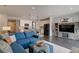 Open-concept living area with blue sectional sofa, kitchen, and modern entertainment center at 1868 Makley Loop, Castle Rock, CO 80104
