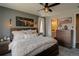 Comfortable main bedroom featuring a ceiling fan, cow artwork, and ensuite bathroom at 1868 Makley Loop, Castle Rock, CO 80104