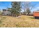 Spacious backyard featuring a home with a deck, patio area, and ample lawn space at 6445 Balsam St, Arvada, CO 80004