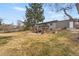 Backyard view highlighting the house, deck, landscaping, and the expansive lawn area at 6445 Balsam St, Arvada, CO 80004