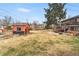 Large backyard featuring a shed, ample lawn space, and established trees at 6445 Balsam St, Arvada, CO 80004