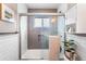 Bright bathroom featuring a glass-enclosed shower with gray tiling, white subway tile, and modern fixtures at 6445 Balsam St, Arvada, CO 80004