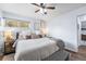Cozy bedroom with a large bed, ceiling fan, hardwood floors, and natural light from the windows at 6445 Balsam St, Arvada, CO 80004