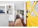 Inviting entryway with a bright yellow door, hardwood floors, and an open view into the living spaces at 6445 Balsam St, Arvada, CO 80004
