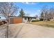 Charming single-story home featuring a well-maintained front yard, long drive, and stylish wooden garage door at 6445 Balsam St, Arvada, CO 80004