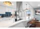 Modern kitchen with white cabinetry, stainless steel appliances, quartz counters, and stylish pendant lighting at 6445 Balsam St, Arvada, CO 80004