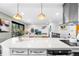Modern kitchen featuring an island, quartz countertops, and stainless steel appliances opening up into the living room at 6445 Balsam St, Arvada, CO 80004