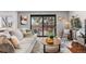 Bright living room with large slider, brick accent wall, and comfortable seating on hardwood floors at 6445 Balsam St, Arvada, CO 80004