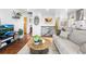 Bright living room with hardwood floors, open floorplan, and modern decor leading into the kitchen at 6445 Balsam St, Arvada, CO 80004