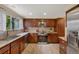 Updated kitchen features modern appliances, granite countertops, stainless steel microwave, and neutral tile backsplash at 8433 S Painted Sky St, Highlands Ranch, CO 80126