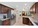 Open kitchen design with granite countertops, stainless steel refrigerator, and easy access to the living area with fireplace at 8433 S Painted Sky St, Highlands Ranch, CO 80126