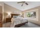 Comfortable main bedroom featuring large window with a window seat and tray ceiling with ceiling fan at 8433 S Painted Sky St, Highlands Ranch, CO 80126