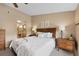 Relaxing main bedroom showcasing neutral colors, large window, comfortable decor, and ensuite bathroom access at 8433 S Painted Sky St, Highlands Ranch, CO 80126