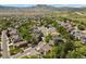 An aerial view shows a densely populated neighborhood with many single Gathering homes and tree lined streets at 2146 S Ellis Ct, Lakewood, CO 80228